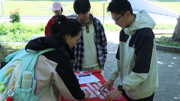 图为在“红色拼图”摊位，学生通过复原历史图片重温五四峥嵘岁月_副本.png